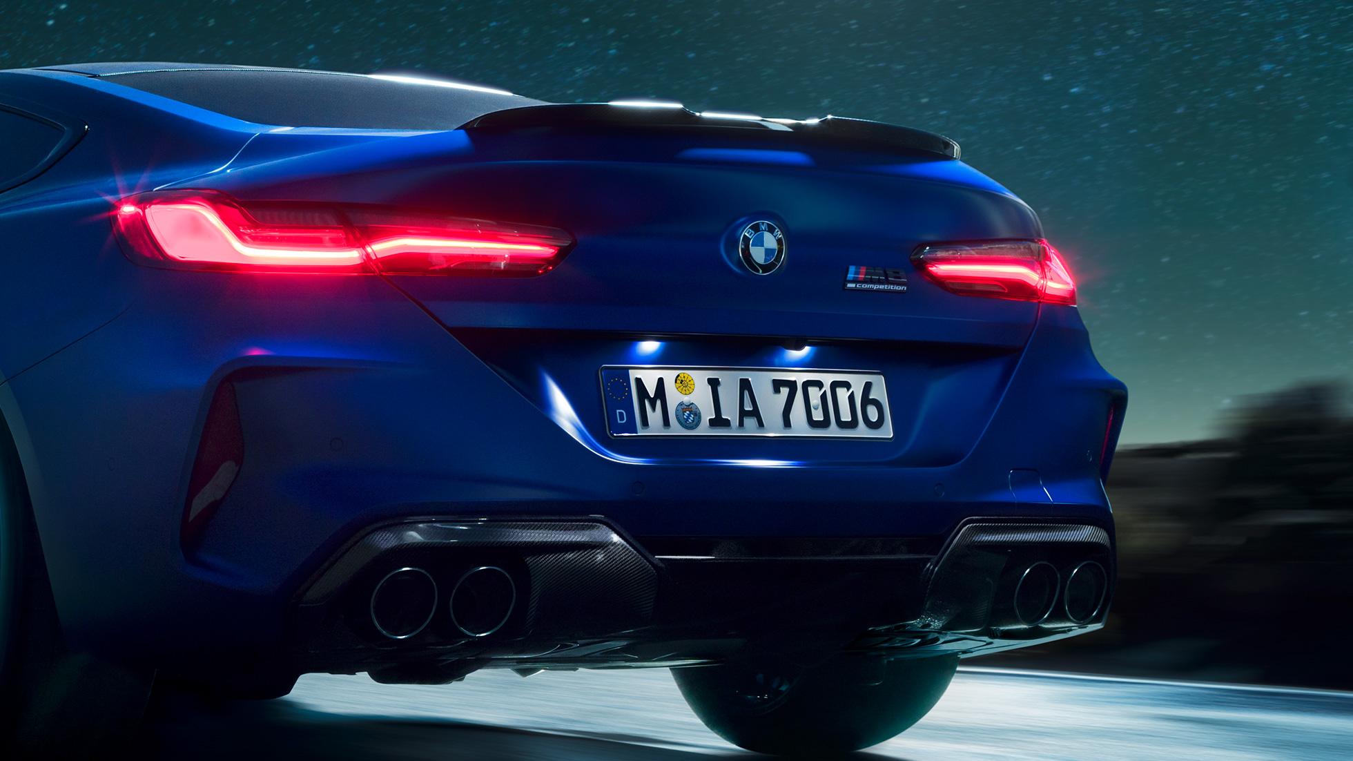 Difusor M en Carbonschwarz. BMW M8 Competition Coupé en Marina Bay Blau metalizado, detalle de la zaga de noche, con difusor M en Carbonschwarz.