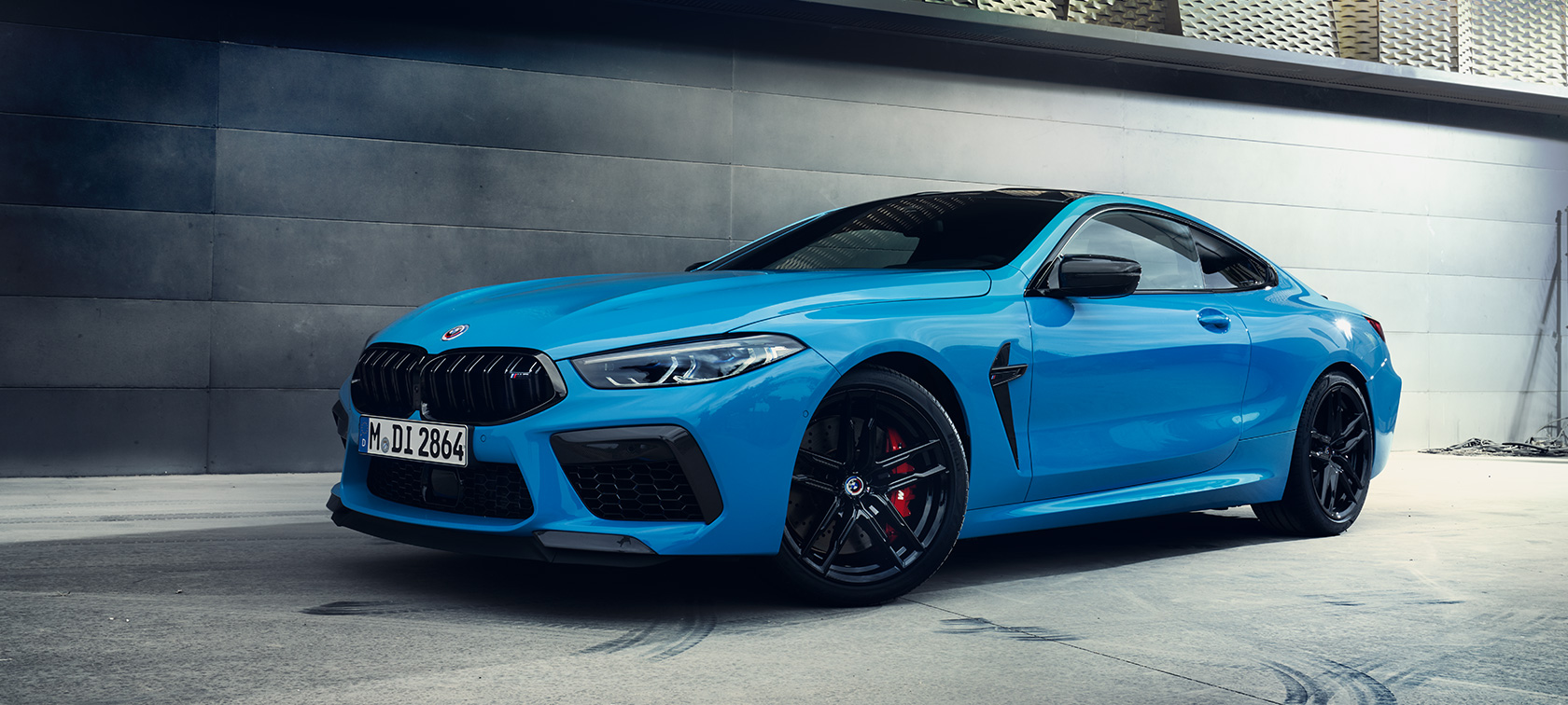 BMW M8 Competition Coupé F92 LCI Renovación 2022 Daytona Beach Blue sólido, vista de tres cuartos del lateral, parado, ante una pared