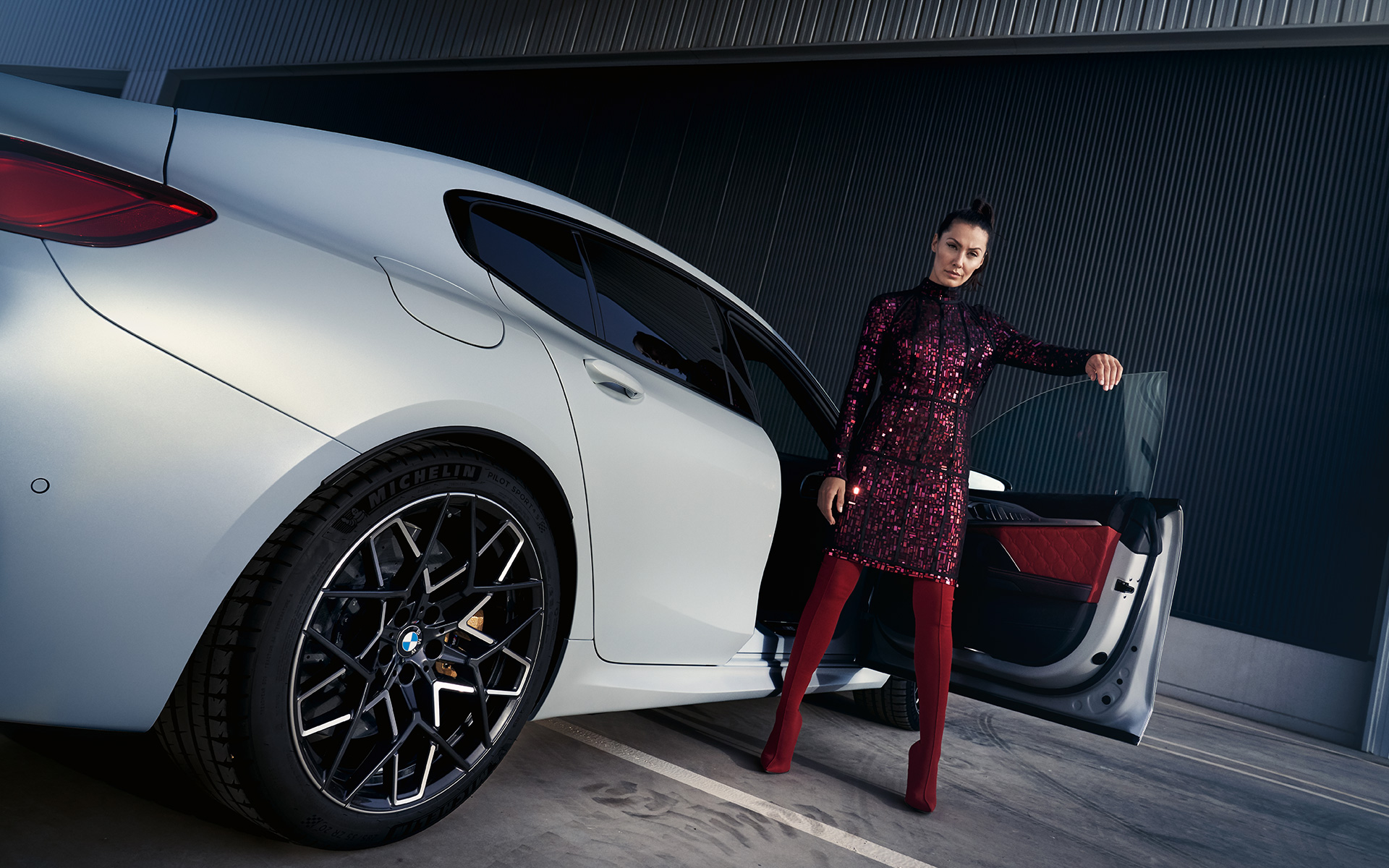 BMW M8 Competition Gran Coupé F93 LCI 2022 vista de tres cuartos de la zaga, con modelo, con perspectiva desde ángulo inferior BMW M8 Competition Gran Coupé F93 LCI Renovación 2022 BMW Individual Frozen Brilliant White metalizado, vista de tres cuartos de la zaga, con modelo, perspectiva desde ángulo inferior