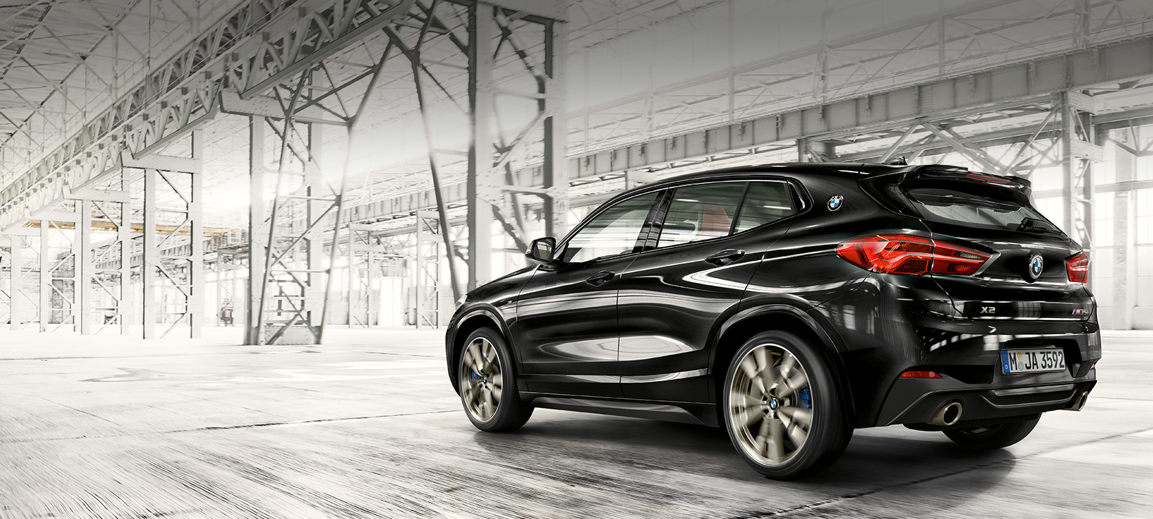 Vista de tres cuartos de la zaga BMW X2 M35i Vista lateral de trasera del SUV deportivo BMW X2 M35i en movimiento