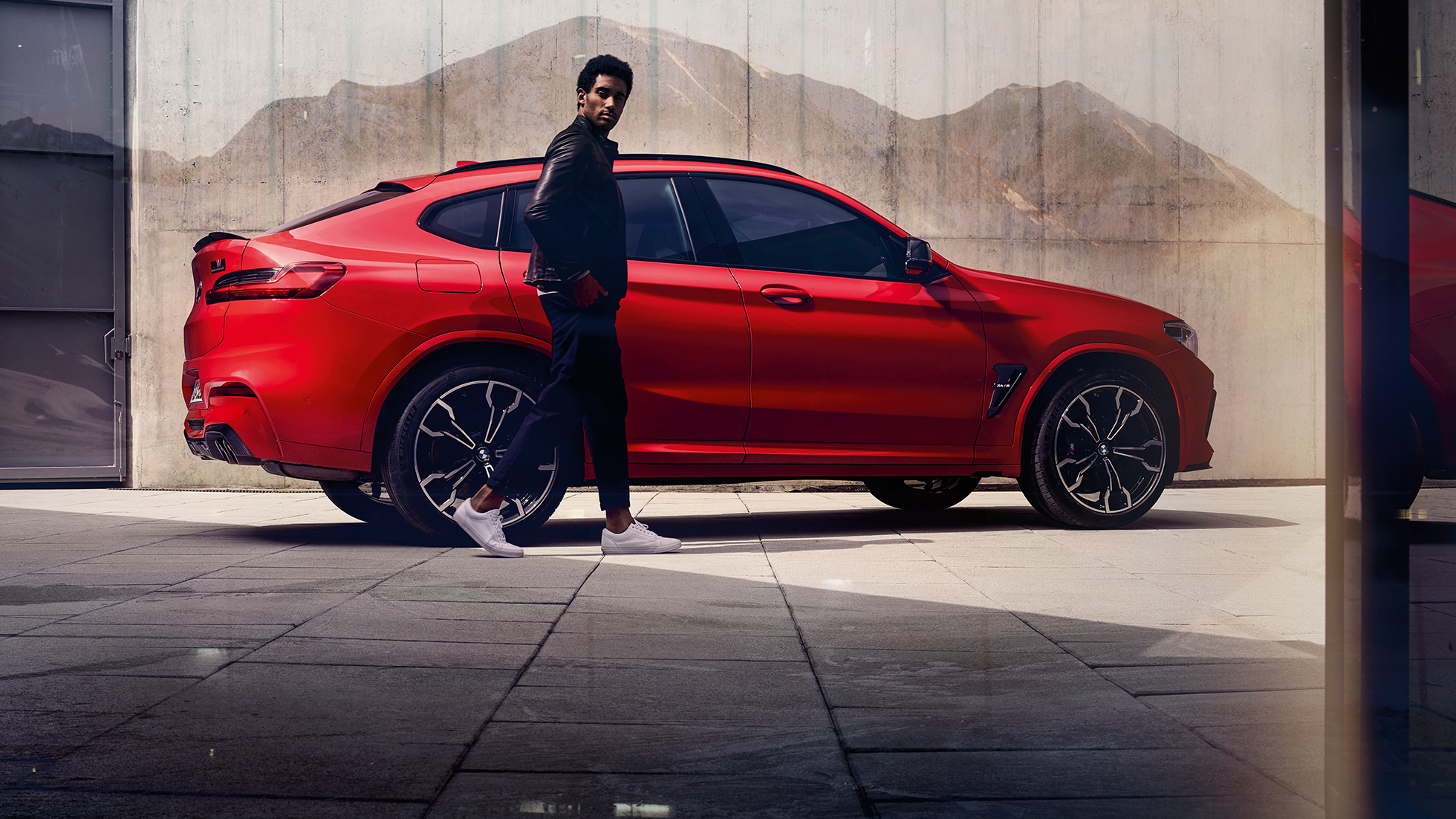 BMW X4 M Competition, vista del lateral con un joven BMW X4 M Competition en Toronto Rot metalizado, exterior, vista del lateral con un joven