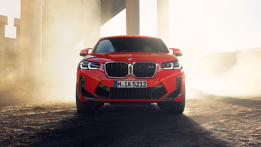 BMW X4 M F98 LCI Renovación 2021 Toronto Rot metalizado Vista del frontal delante de columnas de un puente