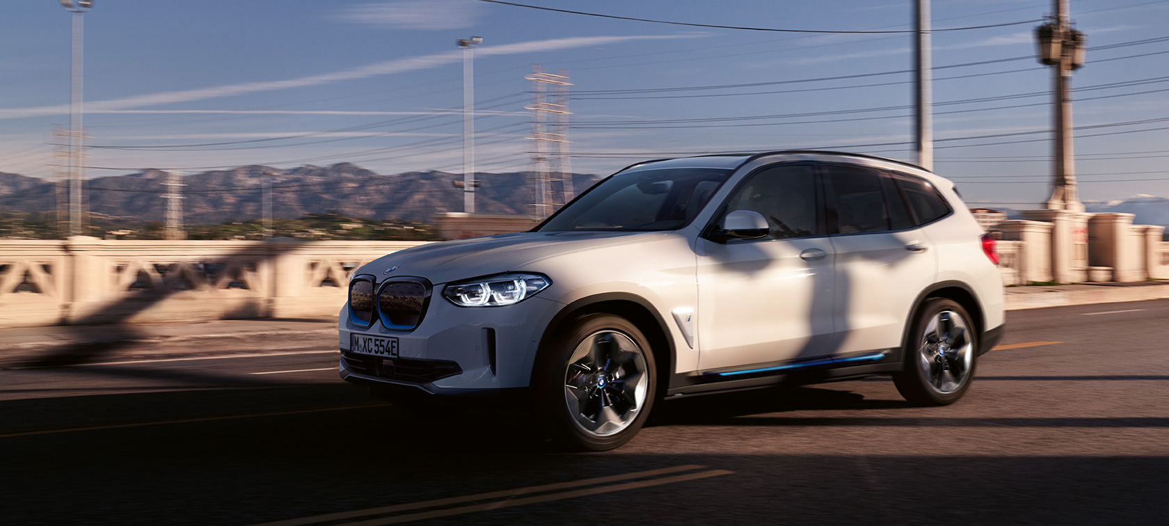 BMW iX3 SUV G08 Vista de tres cuartos del frontal, en marcha en la carretera BMW iX3 SUV G08 2020 Mineralweiss metalizado Vista de tres cuartos del frontal, en marcha en carretera