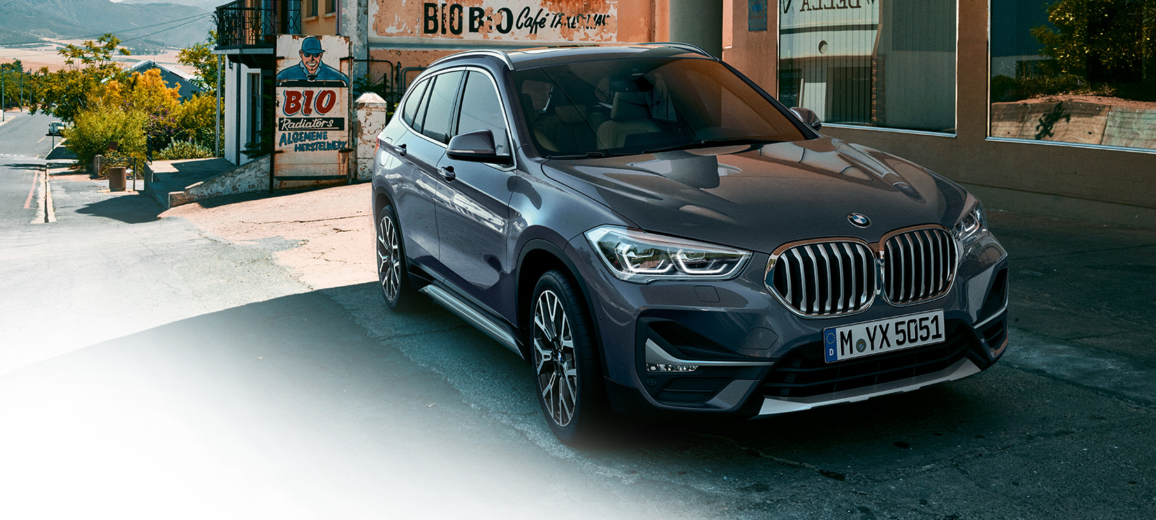 BMW X1 SUV F48, vista de tres cuartos del frontal. BMW X1 SUV F48, vista de tres cuartos del frontal delante de un paisaje urbano.