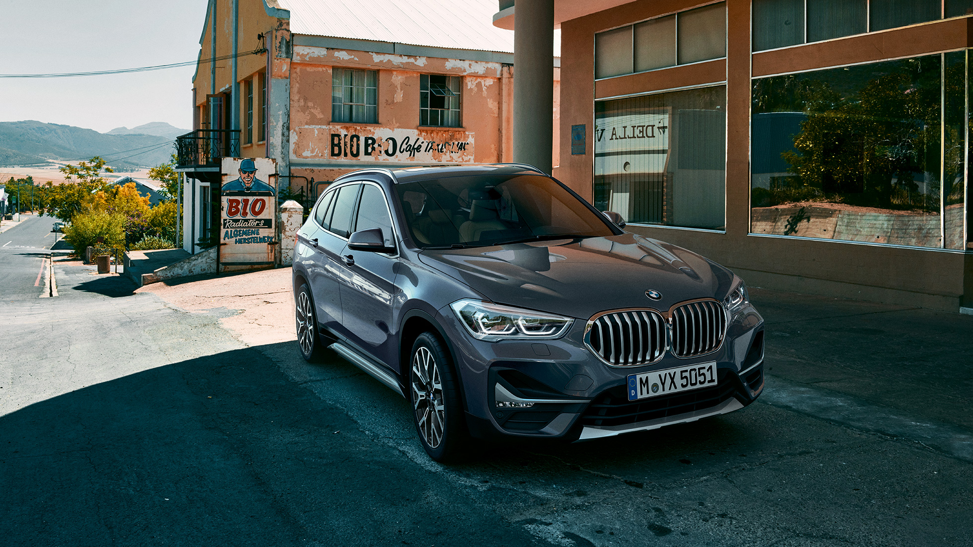 BMW X1, vista de tres cuartos del frontal del todocamino compacto. BMW X1, vista de tres cuartos del frontal delante de un paisaje urbano.
