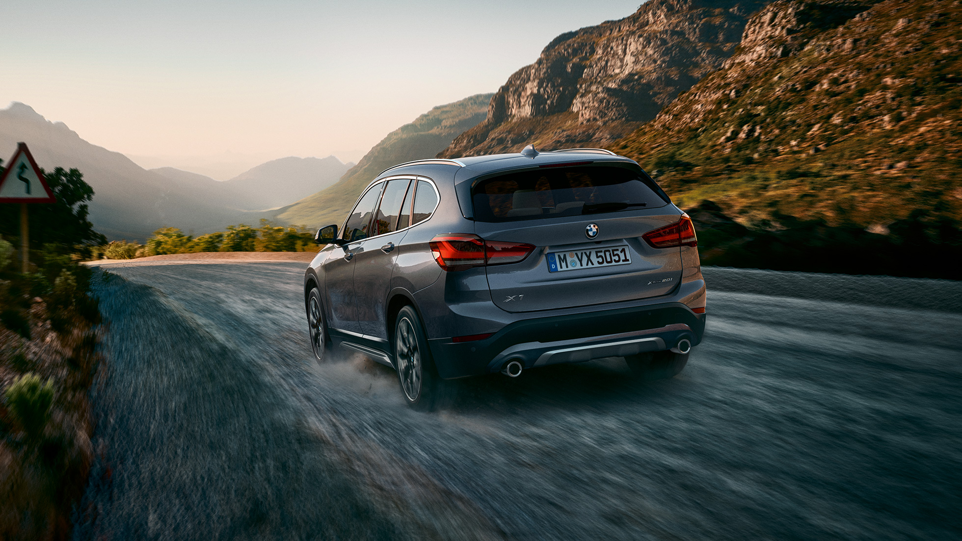 BMW X1, vista de tres cuartos de la zaga. BMW X1, vista de tres cuartos de la zaga delante en un paisaje montañoso.