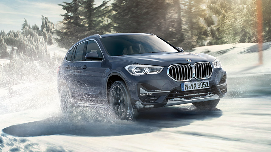 BMW X1 xDrive20i F48 LCI en BMW Individual Storm Bay metalizado, en marcha, en un paisaje de invierno BMW X1 xDrive20i F48 LCI en BMW Individual Storm Bay metalizado, en marcha, en un paisaje de invierno