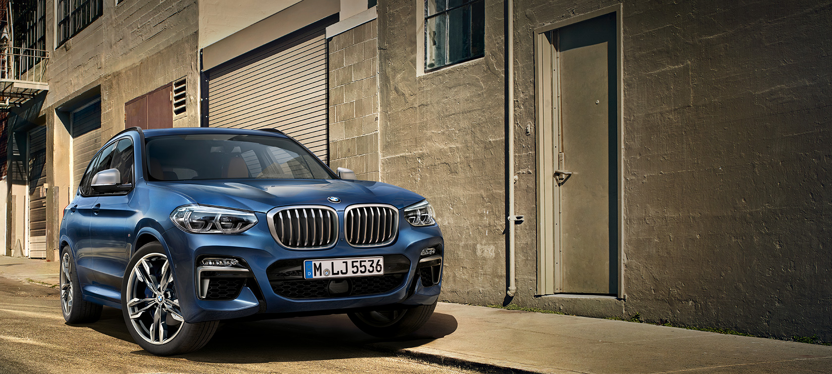 BMW X3 M40i, imagen delante de la pared de una casa BMW X3 M40i, imagen delante de la pared de una casa