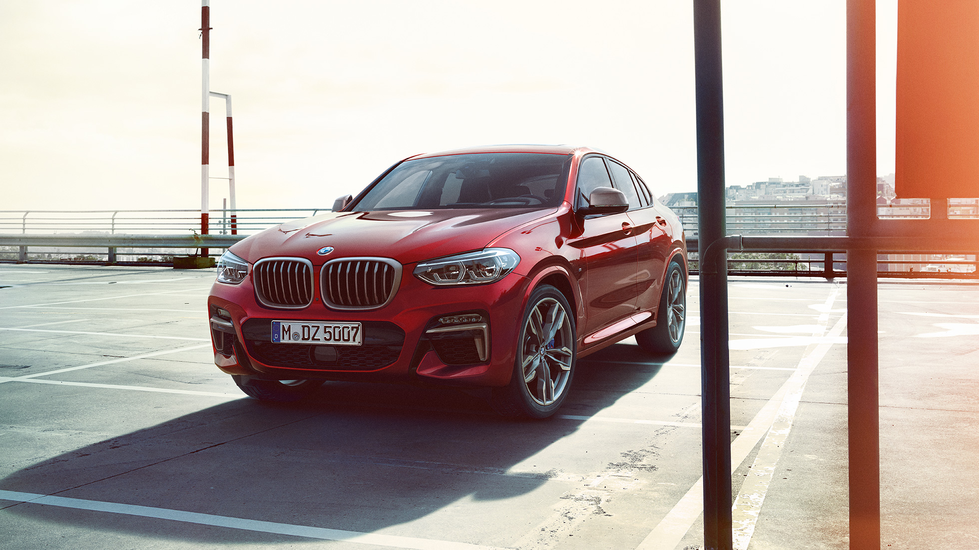 BMW X4 exterior BMW X4 M40i G02 en color Flamencorot efecto brillante, vista de tres cuartos del frontal del SUV Coupé