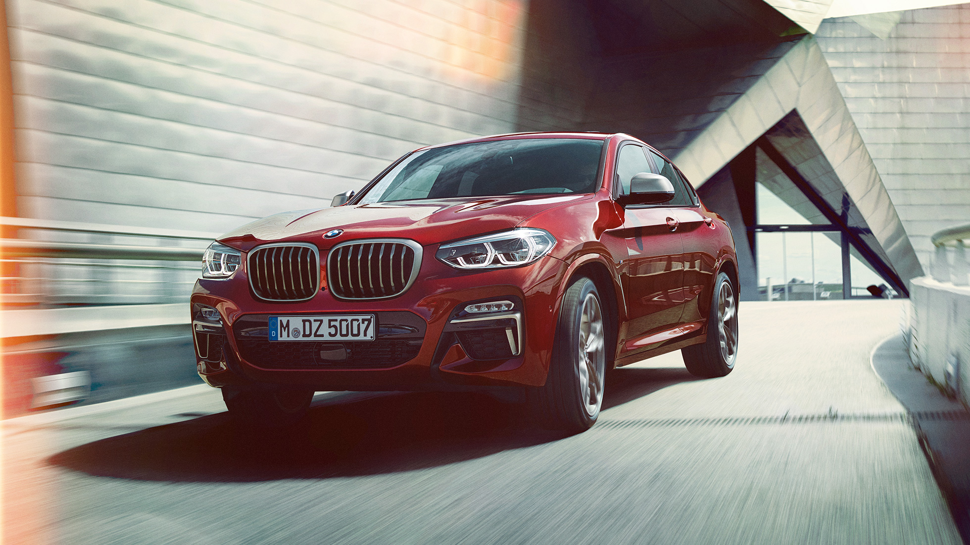 Vista de tres cuartos del frontal BMW X4 BMW X4 M40i G02 en color Flamencorot efecto brillante, vista de tres cuartos del frontal