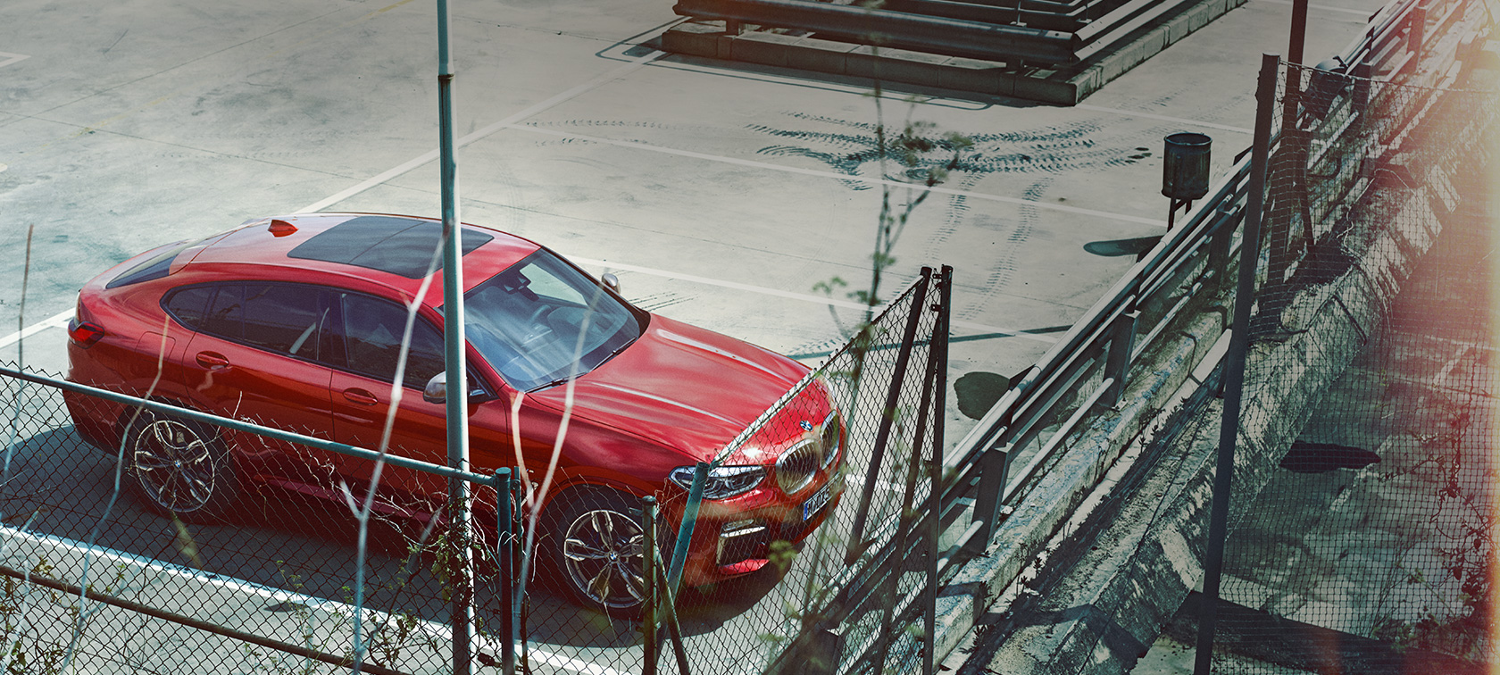 BMW X4 estacionamiento BMW X4 G02 en color Flamencorot efecto brillante, estacionamiento en planta de aparcamiento, vista aérea