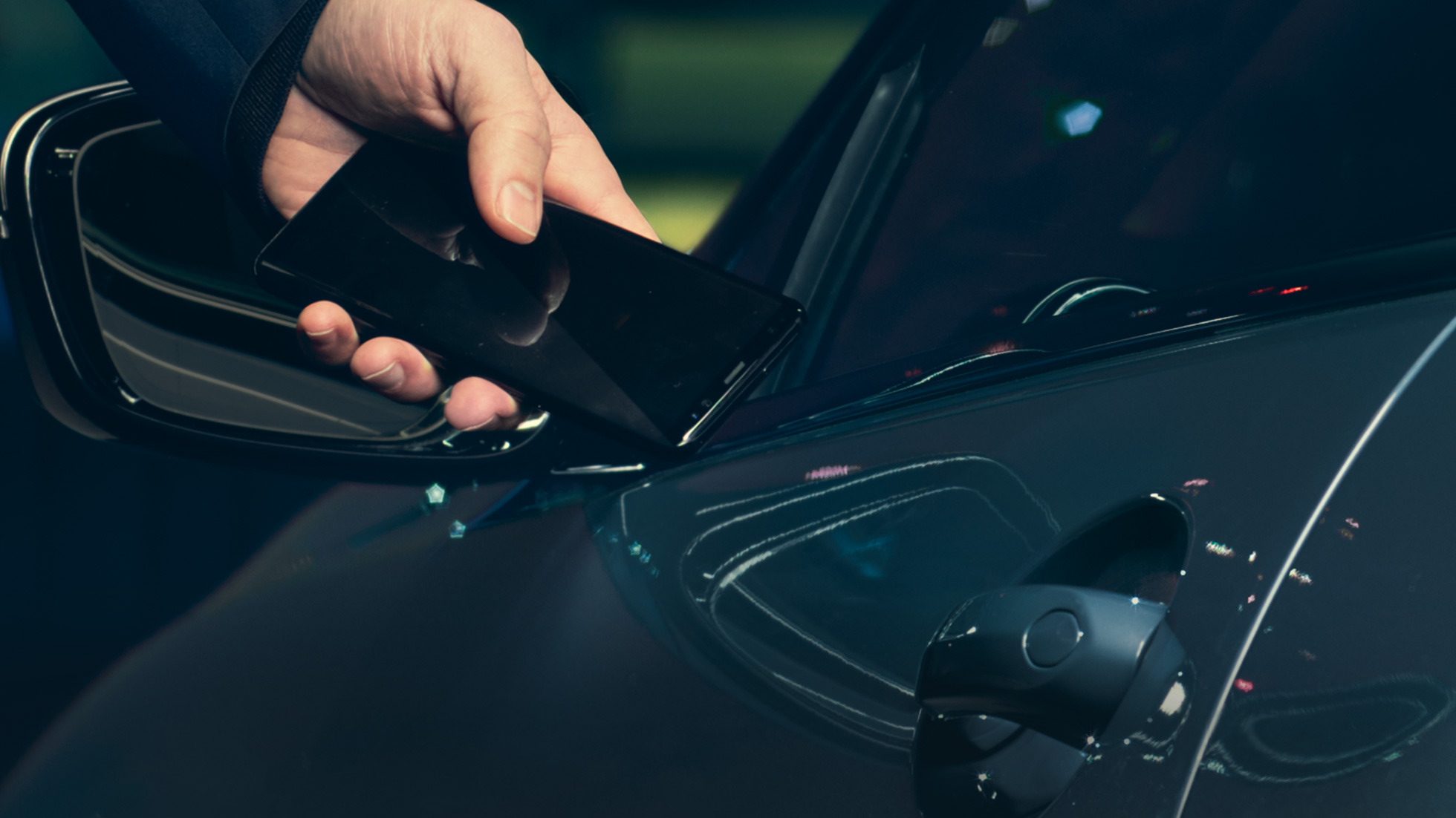 BMW Digital Key BMW Digital Key Hombre sosteniendo su smartphone junto a la puerta del vehículo en el exterior