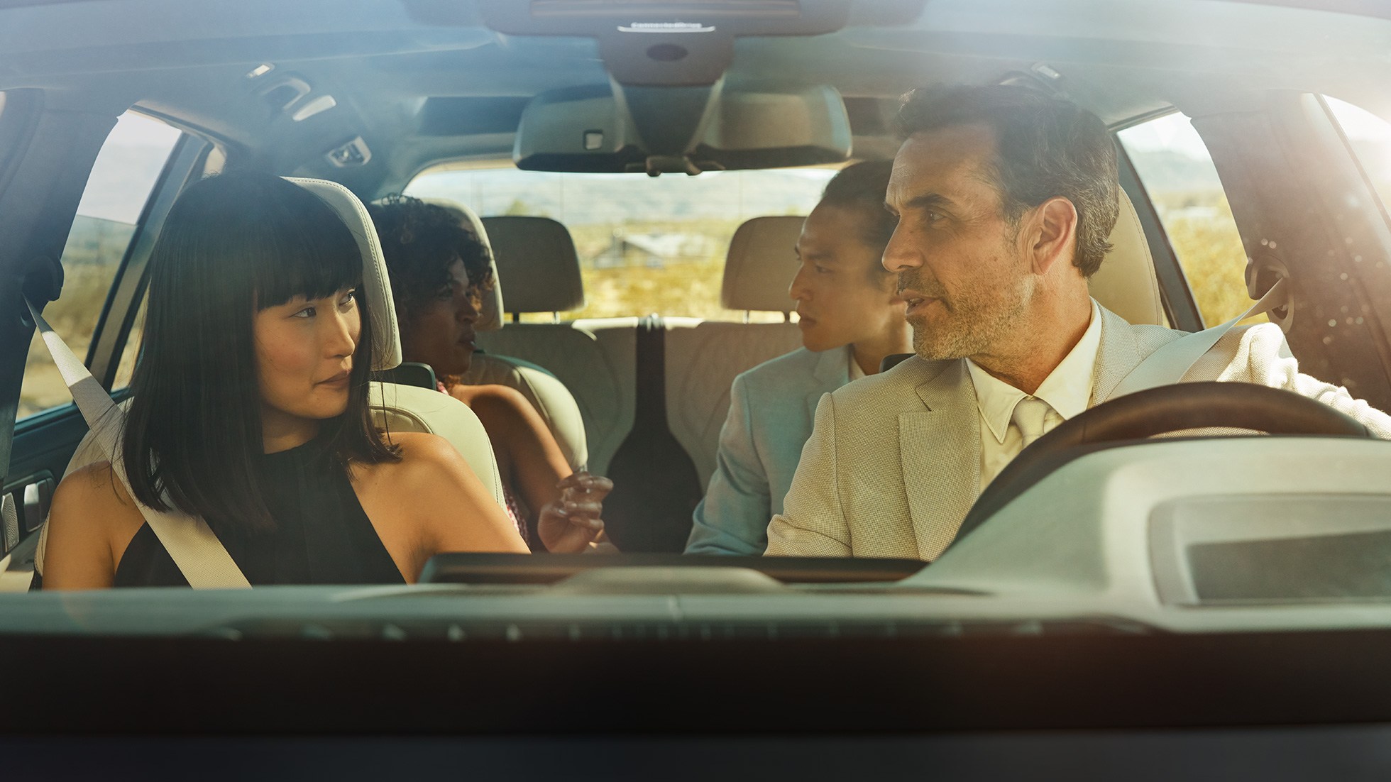 Control de gestos BMW Hombre y mujer sentados en el vehículo; la mujer está utilizando el control de gestos