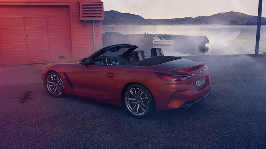 Vista trasera del BMW Z4 First Edition en Orange Vista trasera del BMW Z4 First Edition en Orange delante de una casa roja junto al agua