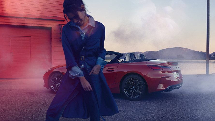 BMW Z4 M40i Roadster G29 con capota abierta BMW Z4 M40i Roadster G29 vista de tres cuartos de la zaga con capota abierta y mujer en primer plano