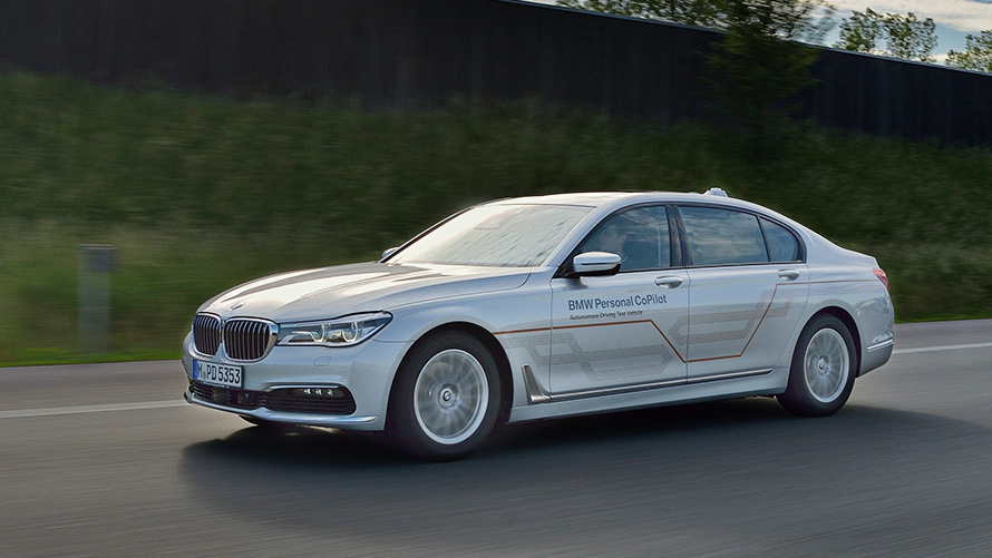 BMW Personal CoPilot: la flota de prueba para conducir de forma autónoma ya hoy Un BMW Serie 5 gris con la inscripción "BMW Personal CoPilot" aparece circulando en la vista lateral izquierda de la autopista.