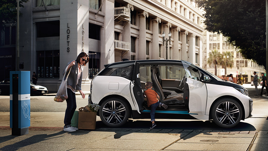 BMW i3 en un entorno urbano Autonomía BMW, BMW i3 en un entorno urbano con mujer y niño