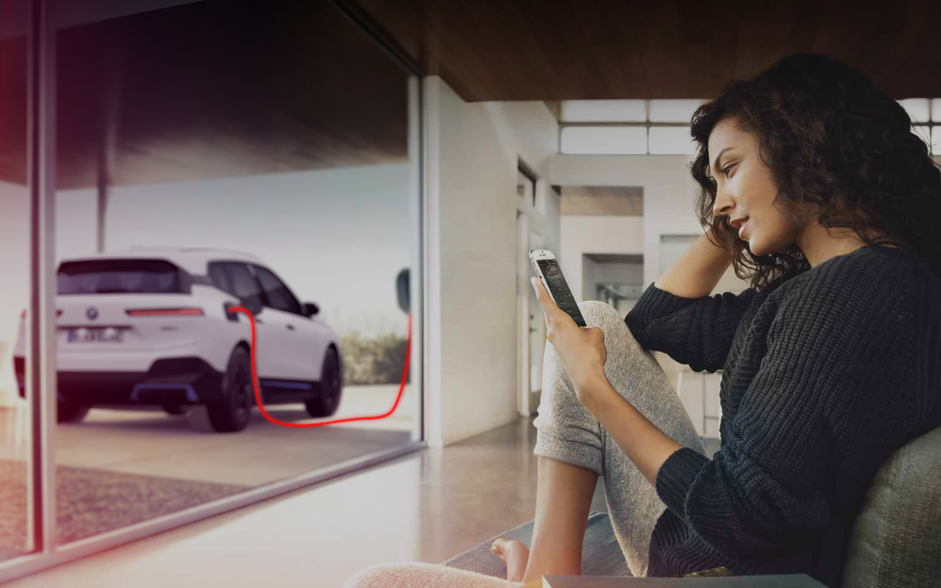 Carga en casa BMW iX i20 Mujer con smartphone