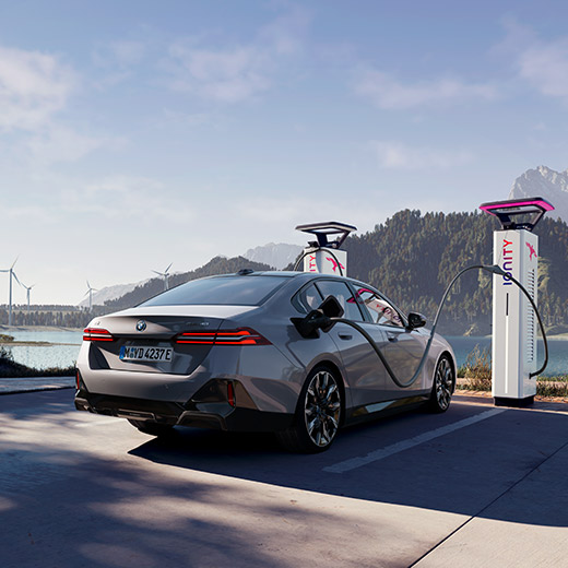 BMW i5 eDrive40 G60 en un punto de carga delante de un lago