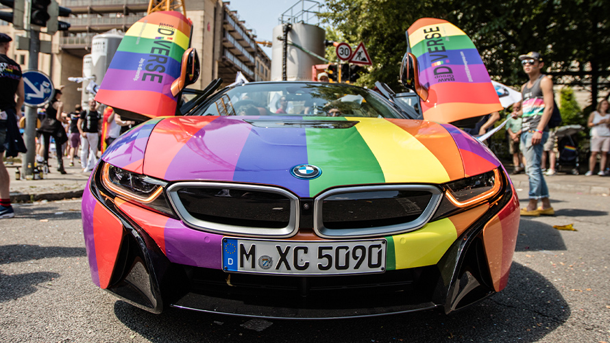 Diversidad BMW Sostenibilidad Diversidad y sostenibilidad de BMW Vista frontal del vehículo BMW en los colores del arco iris con puertas de ala gaviota abiertas