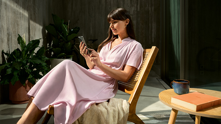 Mujer vestida de rosa con smartphone en la mano, Remote Inside View Remote Inside View, mujer vestida de rosa con smartphone en la mano en una silla