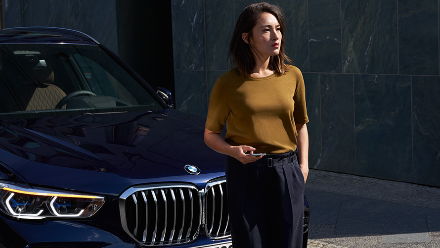 Servicio y Asistencia en caso de avería Una mujer sentada delante de su BMW utiliza Servicio y Asistencia en caso de avería
