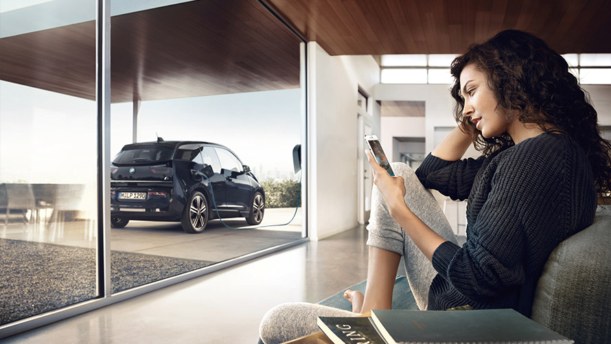 Digital Charging Service Una mujer utiliza la función “Digital Charging Service” en casa en el smartphone para su BMW i3