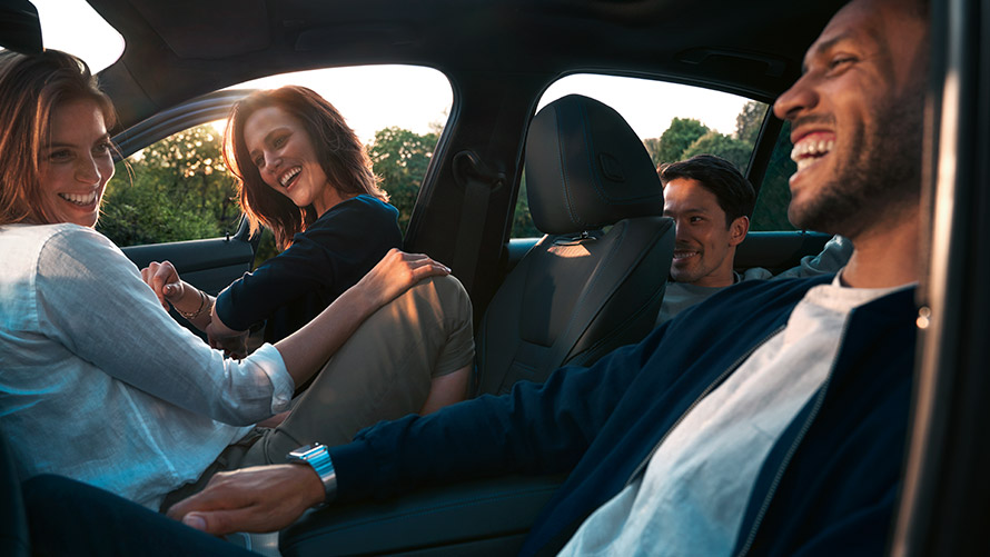 Hombres y mujeres se ríen en un BMW BMW Financial Services Seguro de protección de cuotas BMW Hombres y mujeres se ríen en un BMW