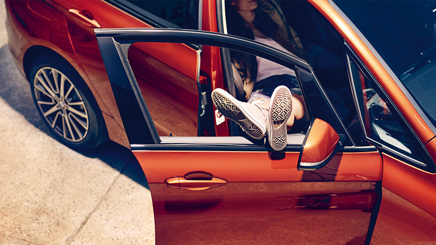 Mujer con los pies en la puerta de un BMW BMW Financial Services Leasing BMW Mujer con los pies en la puerta de un BMW