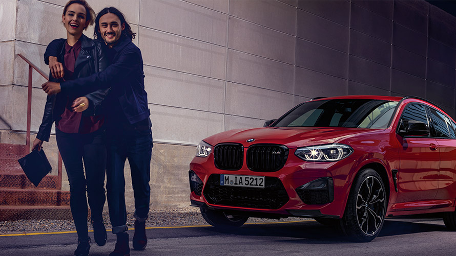 Un hombre y una mujer se ríen delante de un BMW BMW Financial Services Leasing BMW Un hombre y una mujer se ríen delante de un BMW