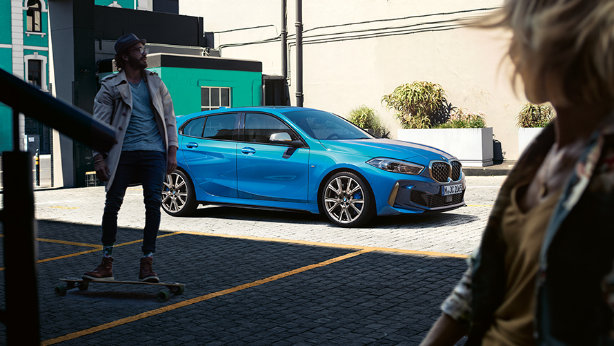 Vista de tres cuartos del lateral de un BMW con hombre sobre monopatín BMW Financial Services Financiación básica BMW Vista de tres cuartos del lateral con hombre sobre monopatín