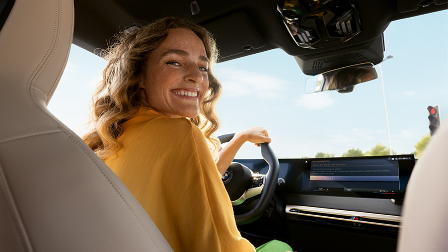 Modo de funcionamiento Proactive Care Proactive Care, Revisión y mantenimiento Modo de funcionamiento Proactive Care Proactive Care, Revisión y mantenimiento, mujer sentada con la mano en el volante en un vehículo BMW
