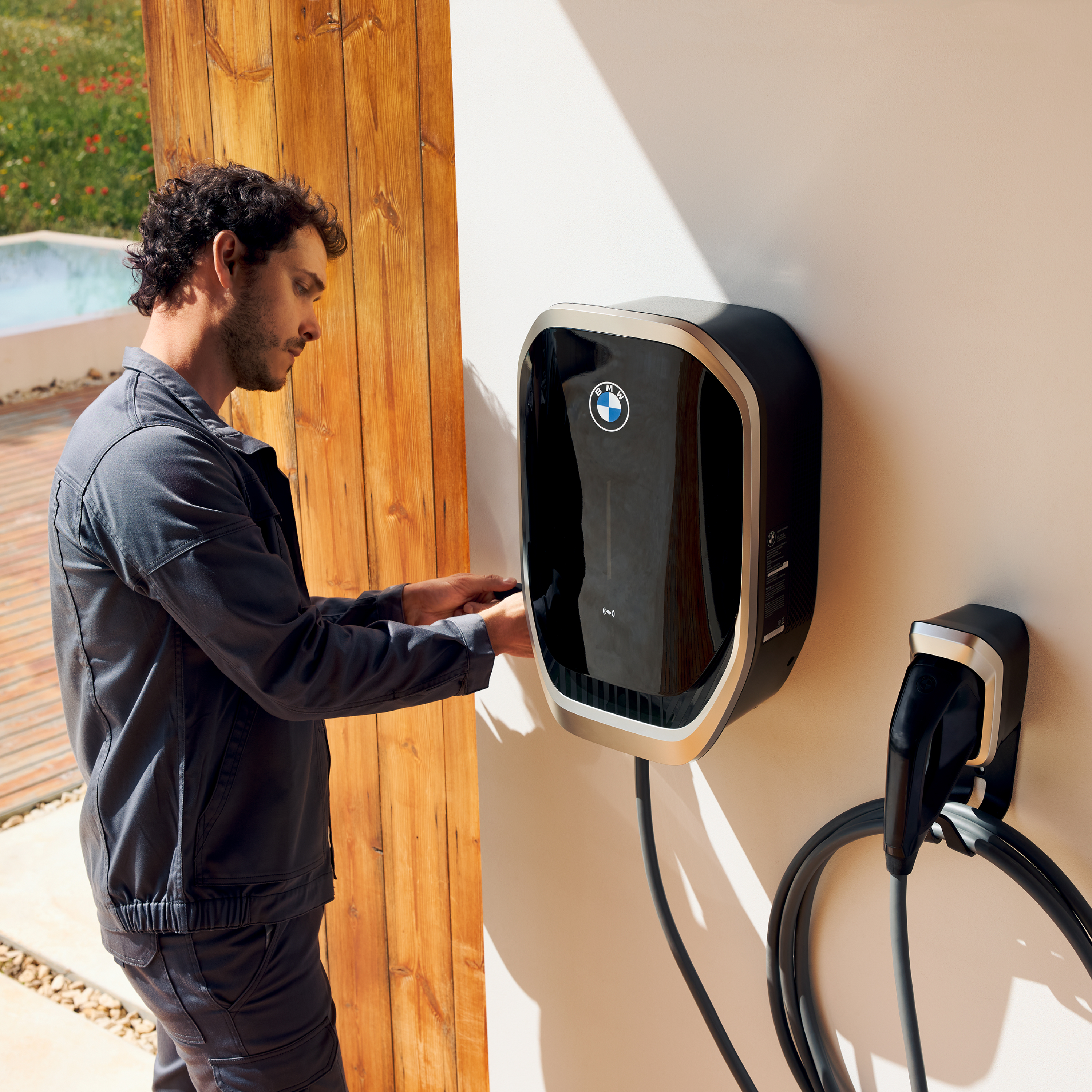 Una persona conectando un cable de carga a un BMW Wallbox