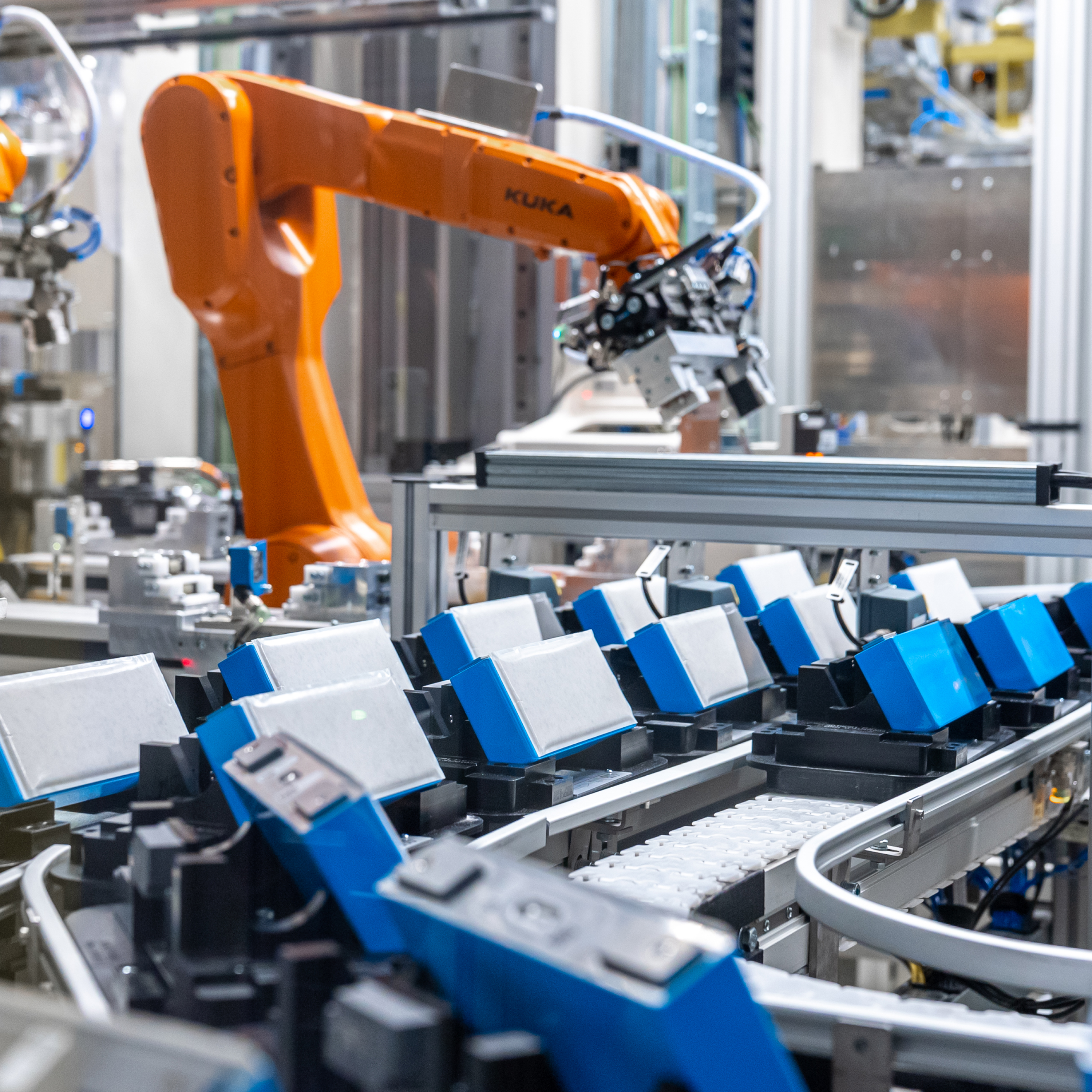 Un primer plano de varias baterías azules y blancas en cinta en la fábrica de BMW